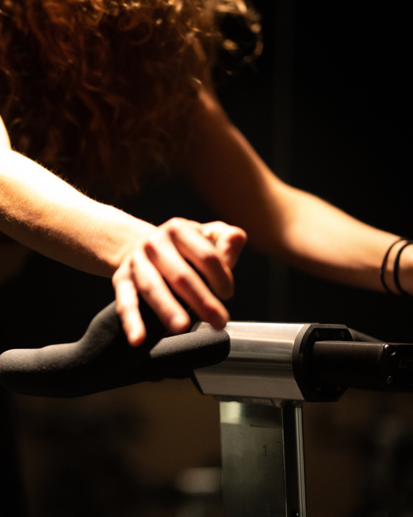 Rhythm-Based Indoor Cycling at The Sweat Lab Durham NC Rider leaning into a rhythm-based indoor cycling workout at The Sweat Lab in Durham, NC