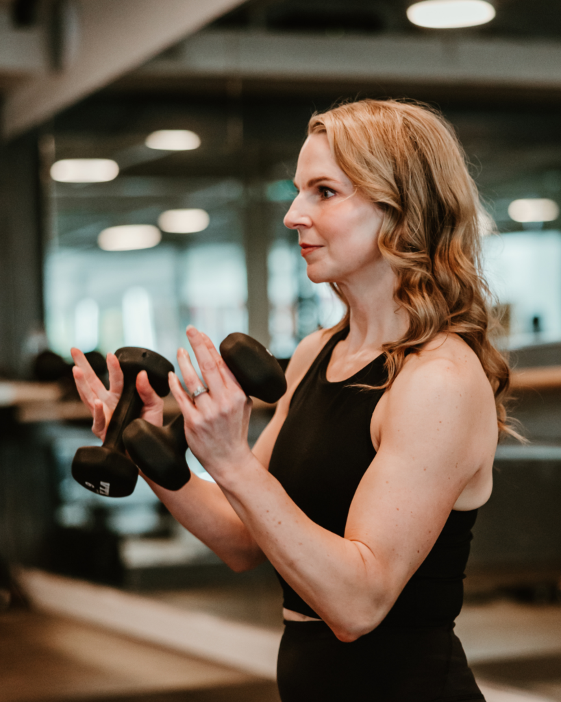 Strength and Sculpt Class at The Sweat Lab Durham NC Strength training instructor demonstrating dumbbell exercises during a sculpt class at The Sweat Lab in Durham, NC
